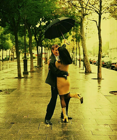 couple embracing and dancing under umbrella