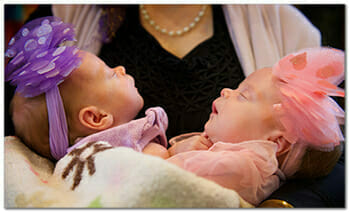 twin girls in mother's arms 