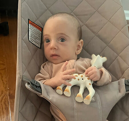 Fertile Heart Baby Rafaeli with toy in baby seat